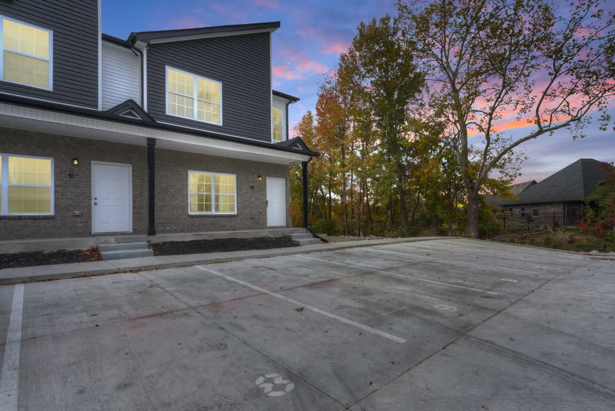 This exterior image showcases the welcoming building facade surrounded by mature trees. Families can be seen gathering outside, with children playing and adults enjoying the peaceful ambiance. The porch offers a prime spot for watching sunsets and savoring tranquil mornings.